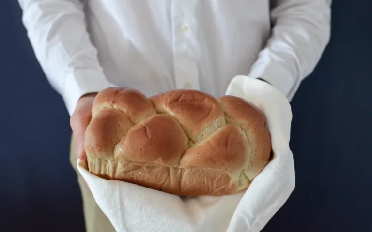 Local bakery owner holding a freshly baked loaf of bread